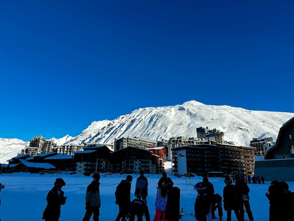 a group of people standing on top of a snow covered slope